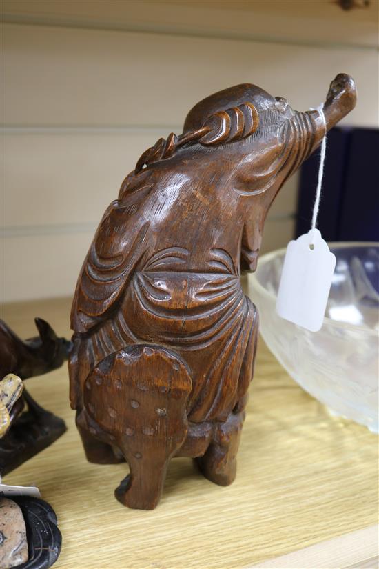 Three Chinese figural wood carvings and a soapstone carving of a child riding a water buffalo,